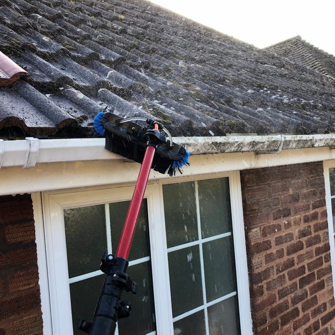 Water-fed pole cleaning uPVC gutter, soffit and fascia on a residential property